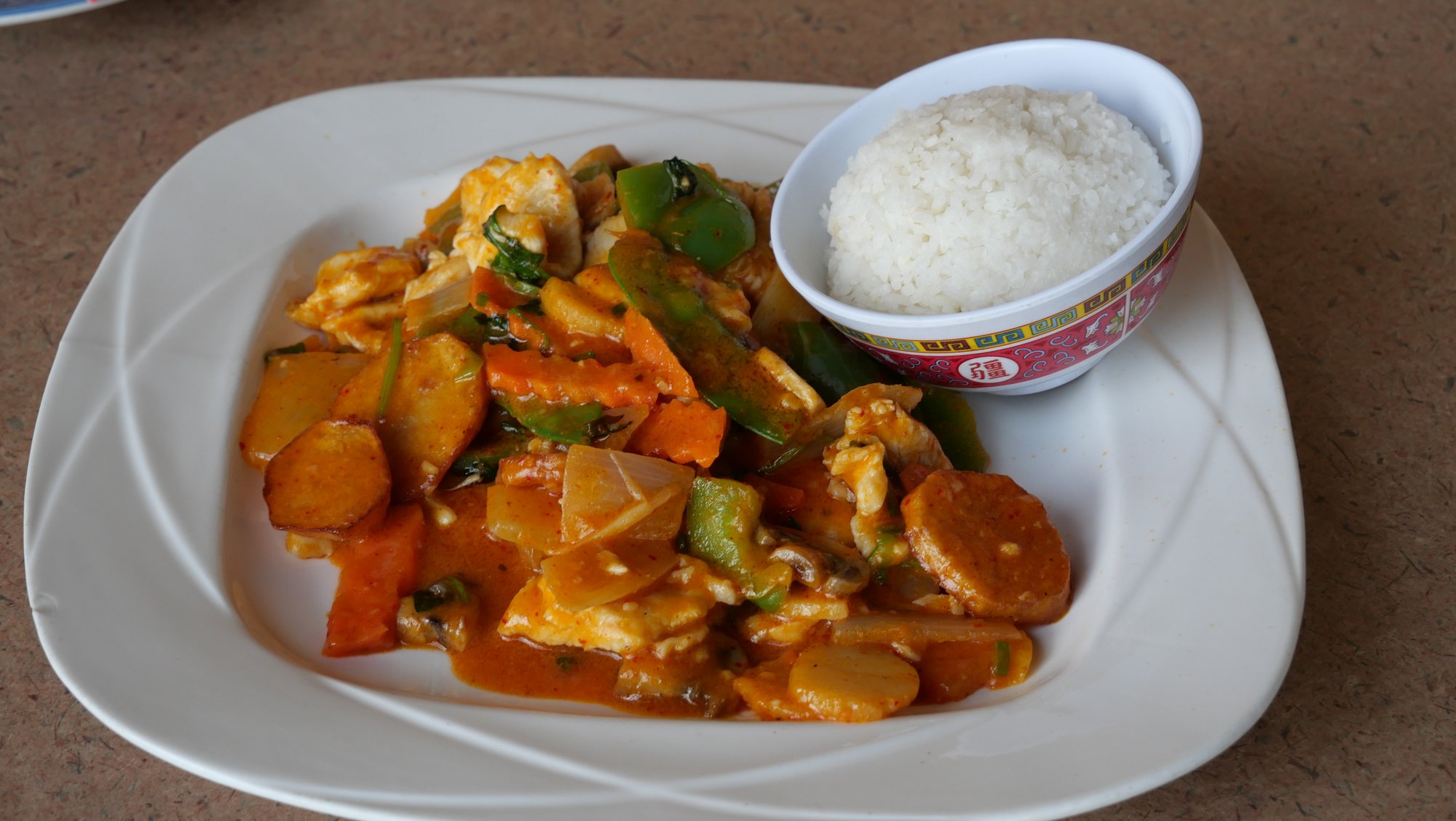 Thai red curry with chicken, vegetables, and bamboo shoots in a coconut sauce served with steamed jasmine rice