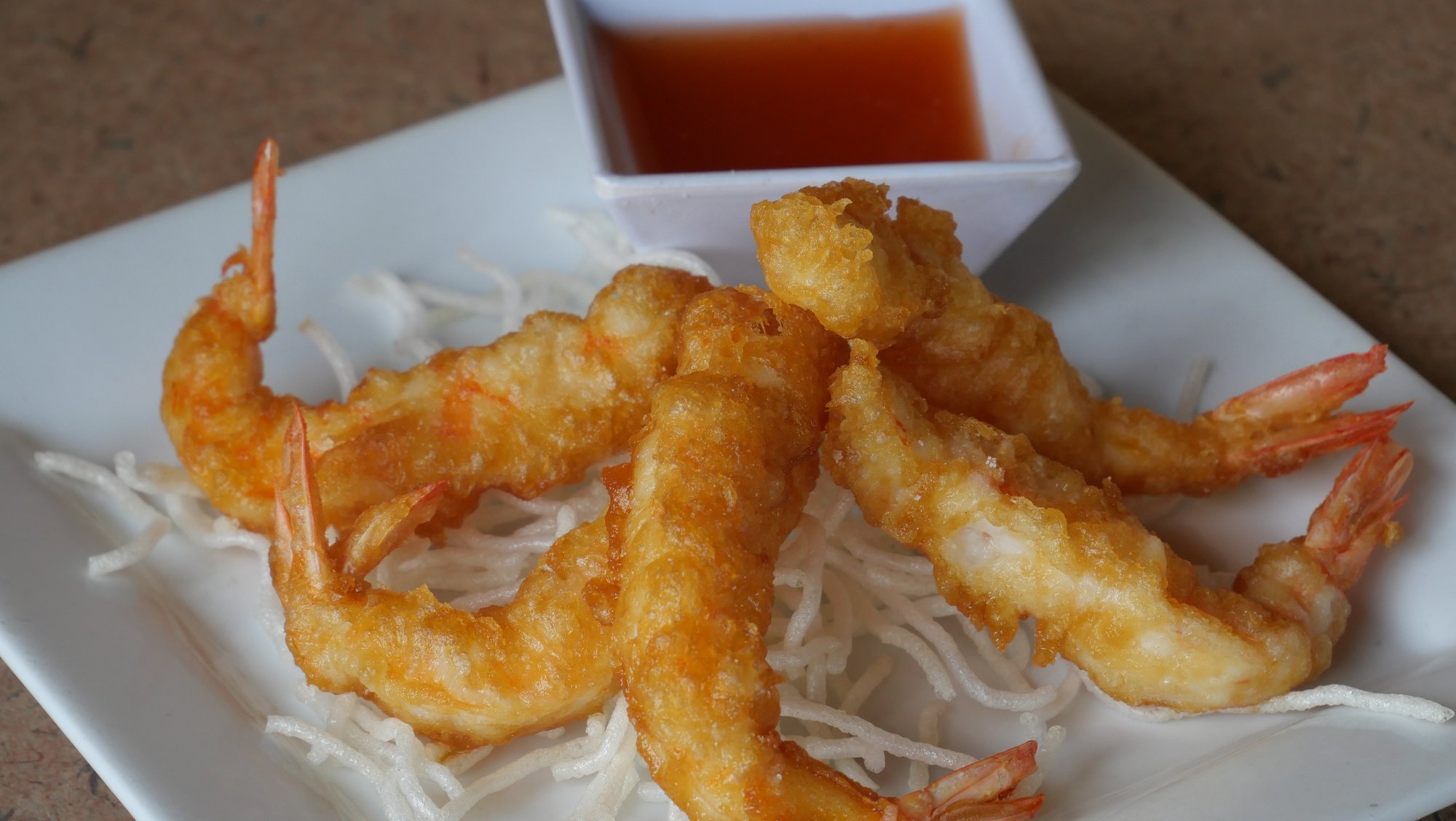 Tempura battered shrimp piled on crispy rice noodles with sweet chili dipping sauce